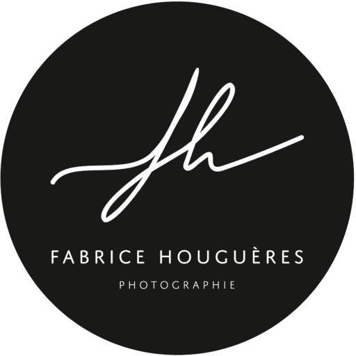 Logo de Fabrice HOUGUERES photographe de mariage. Le logo est rond sur un fond noir. FH est ecrit dessus